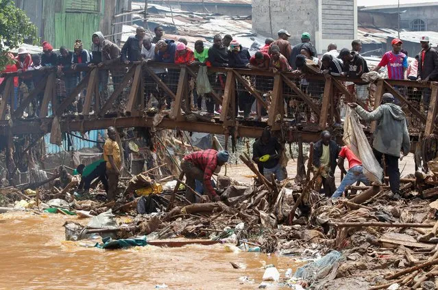 Residents sift through the rubble as they recover their belongings after the Nairobi river burst its banks and destroyed their homes within the Mathare Valley settlement in Nairobi, Kenya on April 25, 2024. (Photo by Monicah Mwangi/Reuters)