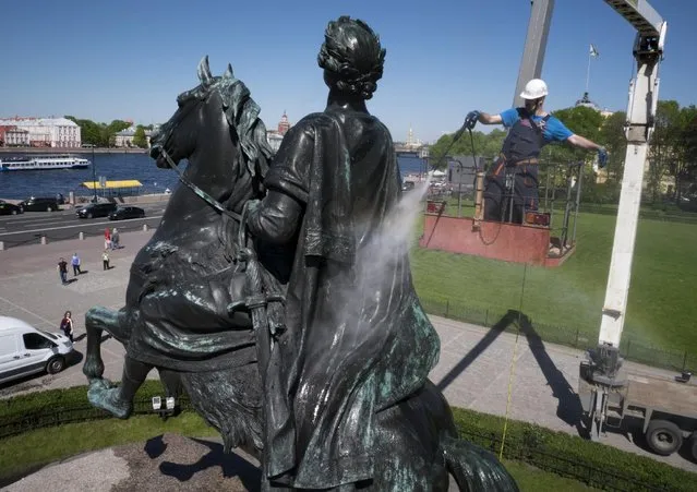 A worker washes a city landmarks, the equestrian statue of Peter the Great known as the Bronze Horseman by French sculptor Etienne Maurice Falconet, in St. Petersburg, Russia, Monday, May 25, 2015. (Photo by Dmitry Lovetsky/AP Photo)