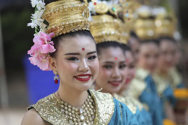 Thai tradition dancers prepare before a religious ceremony near the Tham Luang cave in Mae Sai, Chiang Rai province, Thailand Monday, June 24, 2019. The 12 boys and their coach attended a Buddhist merit-making ceremony at the Tham Luang to commemorate the one-year anniversary of their ordeal that saw them trapped in a flooded cave for more than two weeks. (Photo by Sakchai Lalit/AP Photo)