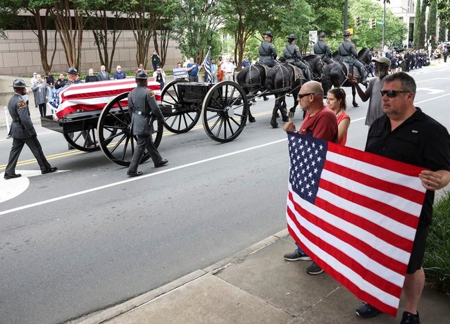 A horse-drawn carriage carries the body of officer Joshua Eyer to First Baptist Church on Friday, May 3, 2024. Officer Eyer was killed while serving a warrant in east Charlotte on Monday, April 29. (Photo by Melissa Rodriguez/AP Photo)