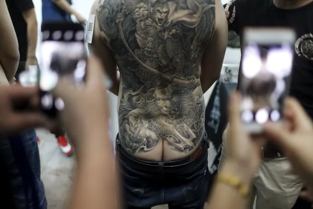 People use their mobile phones to take pictures of a participant after a tattoo contest during an exhibition of 2016 Shanghai International Art Festival Of Tattoos in Shanghai, China, April 22, 2016. (Photo by Aly Song/Reuters)