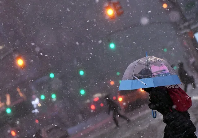 People walk the snow and sleet-covered streets of New York on March 14, 2017. Winter Storm Stella unleashed its fury on much of the northeastern United States on March 14 dropping snow and sleet across the region and leading to school closures and thousands of flight cancellations. Stella, the most powerful winter storm of the season, was forecast to dump up to two feet (60 centimeters) of snow in New York and whip the area with combined with winds of up to 60 miles per hour (95 kilometers per hour), causing treacherous whiteout conditions. But after daybreak the National Weather Service (NWS) revised down its predicted snow accumulation for the city of New York, saying that the storm had moved across the coast. (Photo by Jewel Samad/AFP Photo)