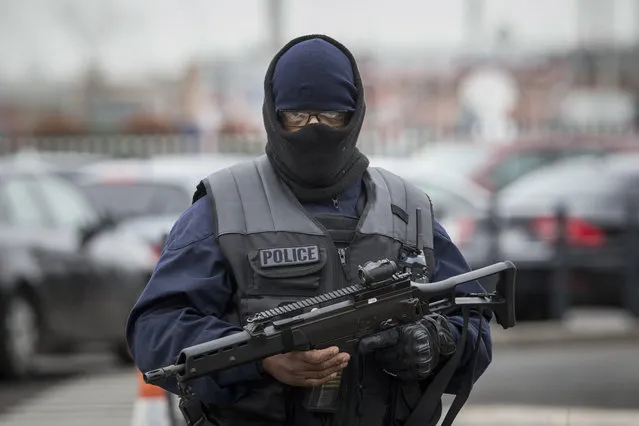 An elite police officer patrols at Orly airport, south of Paris, Saturday, March, 18, 2017. A man was shot to death Saturday after trying to seize the weapon of a soldier guarding Paris' Orly Airport, prompting a partial evacuation of the terminal, police said. (Photo by Kamil Zihnioglu/AP Photo)