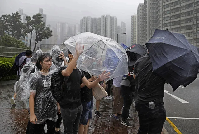 Protesters hold umbrellas against strong winds and heavy rain from Tropical Storm Wipha in Hong Kong Wednesday, July. 31, 2019. The Asian financial center of Hong Kong is shutting down as Wipha approaches, bringing heavy rain and gusts of up to 95 kph (60 mph) in some areas. (Photo by Vincent Yu/AP Photo)