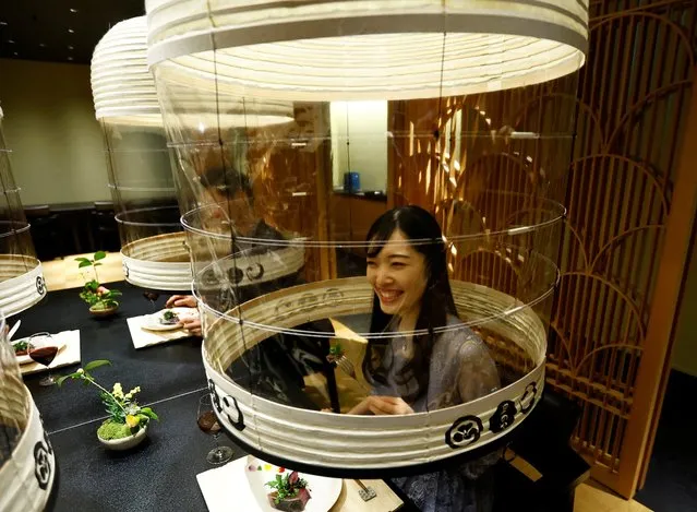 Hotel staff demonstrates “Lantern Dining Experience”, which enables diners to enjoy meals while protecting themselves against the spread of the coronavirus disease (COVID-19) at Hoshinoya Tokyo in Tokyo, Japan, February 2, 2022. The lantern-shaped transparent partitions are created by Japan’s traditional craftsman and guests staying at the hotel who pay 30,000 yen (about 260 USD) as venue charge can invite others to dine with them under the partitions. (Photo by Kim Kyung-Hoon/Reuters)