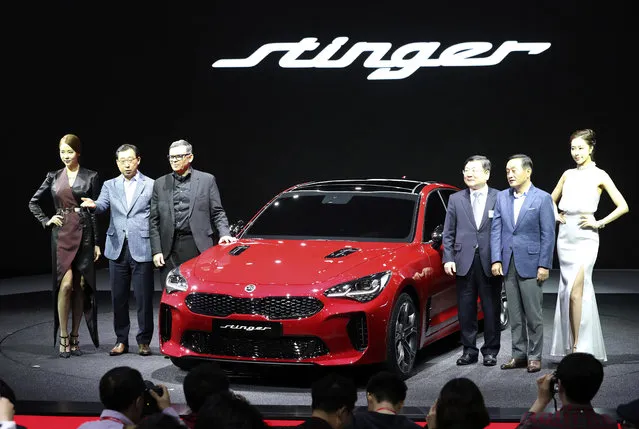 Kia Motors President Park Han-woo, second from left, and Peter Schreyer, chief design officer at Hyundai Motor Group, third from left, pose with Kia Motors' Stinger sedan during a media preview of the 2017 Seoul Motor Show in Goyang, South Korea, Thursday, March 30, 2017. The exhibition will be held from March 31 to April 9 with 27 brands showing their latest cars and concepts. (Photo by Lee Jin-man/AP Photo)