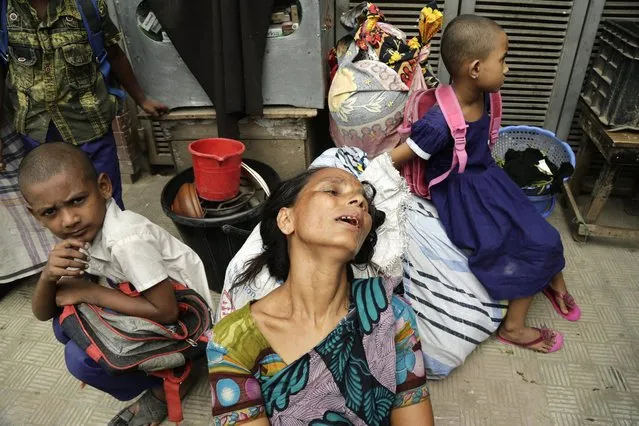 A slum dweller cries sitting in the streets with her belongings after a fire raged through a slum at Ambagan, Farmgate in Dhaka, Bangladesh, 04 May 2016. At least 50 shanties got destroyed in the fire while no casualties were reported and the reason of the fire is yet to known, according to the fire service. (Photo by Abir Abdullah/EPA)