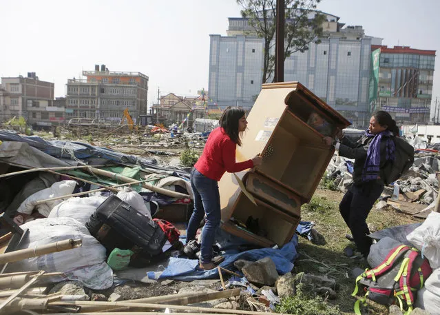 Women collect their belongings from a temporary home after police started removing the quake victims' shelter in downtown Kathmandu, Nepal, Tuesday, March 14, 2017. (Photo by Niranjan Shrestha/AP Photo)