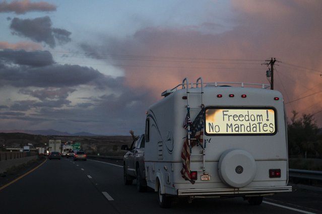 A trailer with the words “Freedom! No Mandate” on its back window travels with a trucker caravan heading toward Washington D.C. to protest COVID-19 mandates on Wednesday, February 23, 2022, near Needles, Calif. (Photo by Nathan Howard/AP Photo)