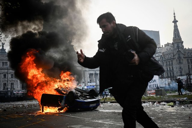 A car burns during a protest near the National Congress, on the day Senators debate Argentina's President Javier Milei's economic reform bill, known as the “omnibus bill”, in Buenos Aires, Argentina, on June 12, 2024. (Photo by Mariana Nedelcu/Reuters)