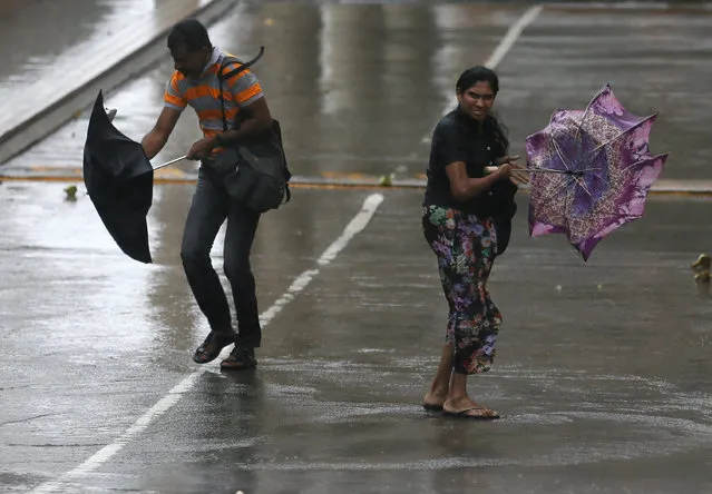 A man and a woman stuggle to hold their umbrellas from high wind and rain during a wet day in Colombo, Sri Lanka May 15, 2016. (Photo by Dinuka Liyanawatte/Reuters)