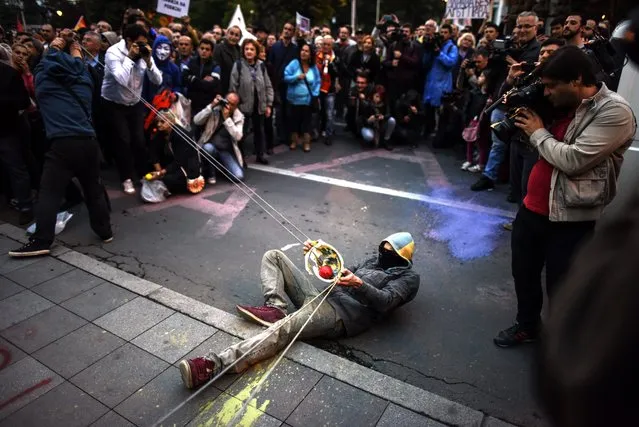 Protestors use an improvised slingshot to launch balloons filled with colored paint at the Parliament building, during a protest dubbed the “Colorful Revolution” against Macedonian President George Ivanov's decision on wiretapping amnesty, in Skopje, The Former Yogoslav Republic of Macedonia, 17 May 2016. Daily protests in Macedonia have been ongoing for almost three weeks, after the President's decision to pardon dozens of politicians who were involved in a wiretapping scandal. (Photo by Georgi Licovski/EPA)