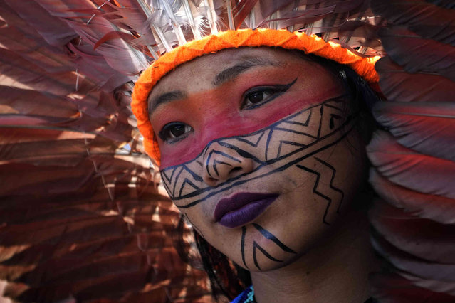 An indigenous woman from the Huni Kuin people takes part in a demonstration in front of Congress to oppose bills that threaten their traditional lives, in Brasilia, Brazil, Monday, April 24, 2023. (Photo by Eraldo Peres/AP Photo)