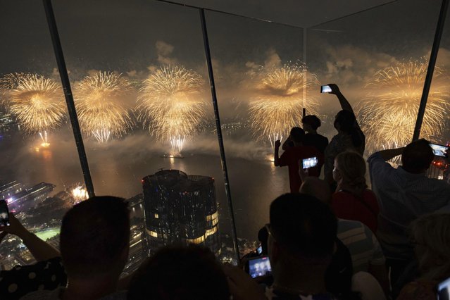 People watch the Macy's Fourth of July fireworks at the Edge at Hudson Yards on Thursday, July 4, 2024, in New York. (Photo by Yuki Iwamura/AP Photo)