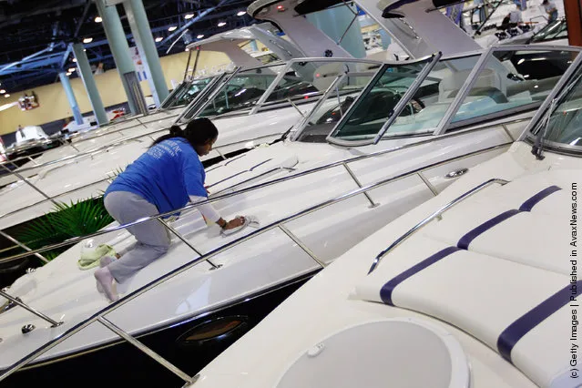 Workers prepare boats for tomorrow's opening day of the four day long Progressive Insurance Miami International Boat Show at the Miami Beach Convention Center