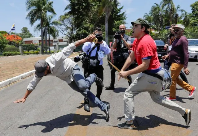 A supporter of Venezuela's President Nicolas Maduro fights with an opposition leader Juan Guaido's supporter outside Venezuelan embassy in Brasilia, Brazil, November 13, 2019. (Photo by Sergio Moraes/Reuters)