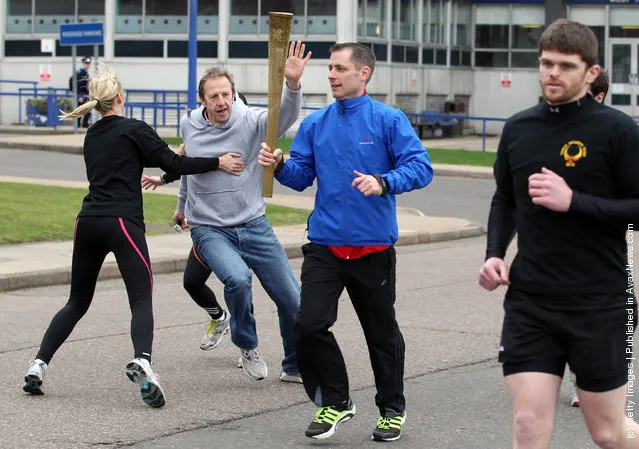 Men stage an attack during a training session for the Olympic Torch Security Team who will be protecting the torch bearers and Olympic flame during the torch relay's progress through the UK, at the Metropolitan Police Training School