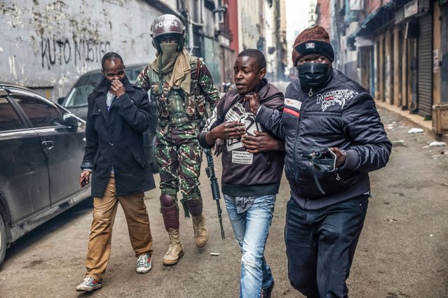 Protestors gesture while being detained by Kenyan security forces during a demonstration in Nairobi on August 8, 2024. Kenyan police were out on the streets of the capital Nairobi, roadblocks were set up on major arteries and many shops were shut on Thursday after young activists called for new anti-government protests. The East African nation has been rocked by weeks of sometimes deadly demonstrations mostly led by young Gen-Z Kenyans against President William Ruto's two-year-old administration. (Photo by Simon Maina/AFP Photo)