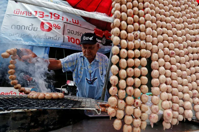A vendor grills sausage as he waits for customers in Nakhon Sawan, Nakhon Sawan Province, Thailand May 7, 2017. (Photo by Chaiwat Subprasom/Reuters)