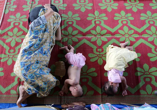 A motehr sleeps with her children as they take shelter with other displaced residents inside an evacuation center in Lanao Del Sur Province, the Philippines, May 31, 2017. More than 29,000 residents of Marawi City are taking shelter in various evacuation centers in Lanao Del Sur Province out up by the Philippine government to keep them safe from the ongoing clashes between government troops and the Maute militant group. (Photo by Rouelle Umali/Xinhua/Barcroft Images)
