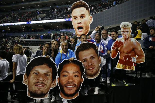 Fans hold cardboard heads of players from the Dallas Mavericks and Detroit Pistons at the end of their regular-season NBA basketball game in Mexico City, Thursday, December 12, 2019. (Photo by Rebecca Blackwell/AP Photo)