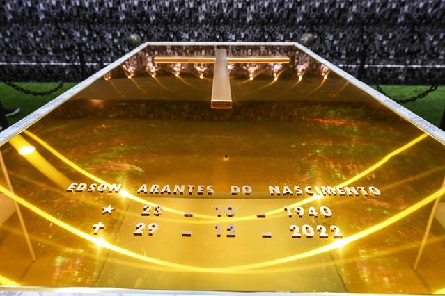 Detailed view of the coffin of late Brazilian football star Pele, in his mausoleum at the Ecumenical Necropolis Memorial cemetery in Santos, Brazil on May 15, 2023. In the 200 m² space, which was opened for visitation today, the public will be able to see a simulation of Santos' fans on the walls, the floor with synthetic grass and a bluish ceiling above the tomb, which is golden and has images of remarkable moments of the career of the Athlete of the Century, who died at the age of 82 on December 29, 2022. (Photo by Nelson Almeida/AFP Photo)