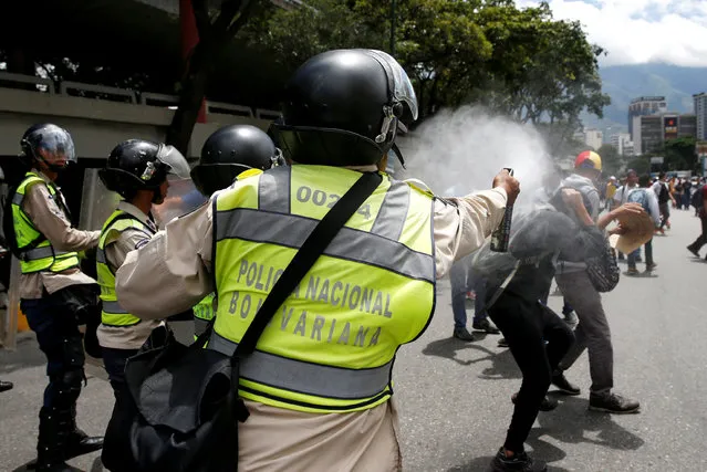 A police officer uses tear gas on demonstrators during a protest called by university students against Venezuela's government in Caracas, Venezuela, June 9, 2016. (Photo by Carlos Garcia Rawlins/Reuters)