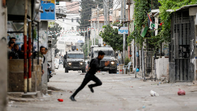 A Palestinian runs amid clashes with Israeli troops during an Israeli raid in Nablus in the Israeli-occupied West Bank on June 13, 2023. (Photo by Raneen Sawafta/Reuters)