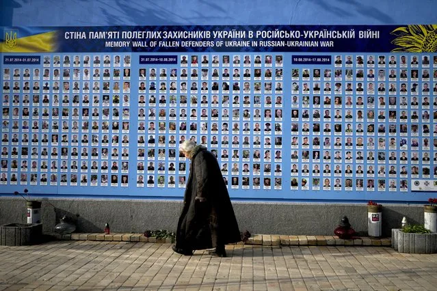 A woman walks past the Memorial Wall of Fallen Defenders of Ukraine in Russian-Ukrainian War in Kyiv, Ukraine, Monday, May 23, 2022. (Photo by Natacha Pisarenko/AP Photo)