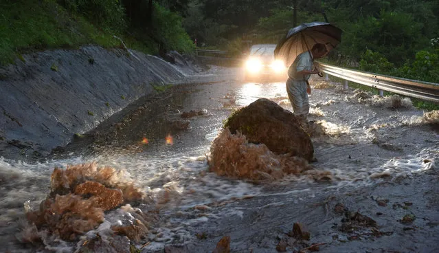 A flooded road with fallen rocks is pictured in Hita in Oita Prefecture, Japan, after torrential rain hits, in this photo taken by Kyodo on July 5, 2017. (Photo by Reuters/Kyodo News)