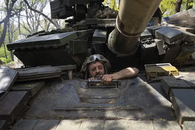 A Ukrainian serviceman enters a tank during the repair works after fighting against Russian forces in Donetsk region, eastern Ukraine, Wednesday, April 27, 2022. (Photo by Evgeniy Maloletka/AP Photo)