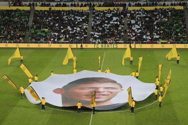 A giant canvas showing late Argentinian player Emiliano Sala is pictured in La Beaujoire stadium prior the French League One soccer match between Nantes against Bordeaux in Nantes, western France, Sunday, January 26, 2020. Nantes paid an emotional tribute to Emiliano Sala by wearing a special blue and white. (Photo by Michel Euler/AP Photo)