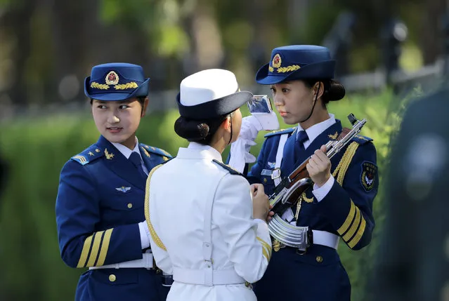 A female member of the honor guard checks her make-up as she prepares for an official welcoming ceremony outside the Great Hall of the People in Beijing. (Photo by Jason Lee/Reuters)