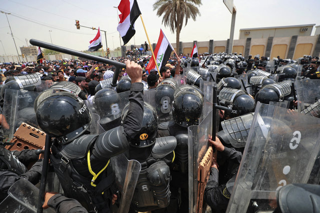 Iraqi security forces deploy to disperse protesters during a demonstration against the government's employment policy near the parliament building in Baghdad's Green Zone on June 7, 2022. The unemployment rate among young people in Iraq is 40%, and a third of its population of more than 40 million people suffers from poverty. (Photo by Ahmad Al-Rubaye/AFP Photo)