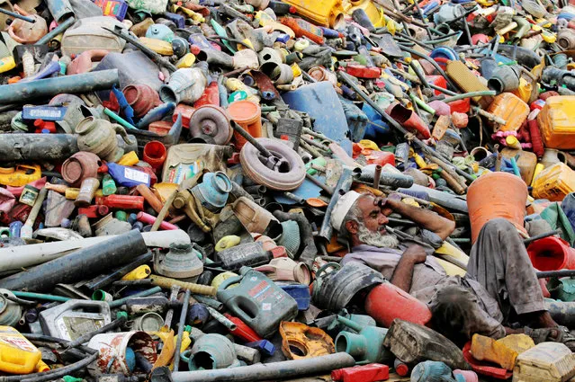 A labourer rests over a pile of recyclables at a yard in Peshawar, Pakistan, August 17, 2017. (Photo by Fayaz Aziz/Reuters)