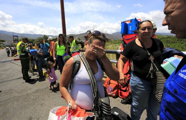 A Colombian woman cries after being deported from Venezuela, as she arrives with her family at the Simon Bolivar bridge border, near Villa del Rosario village, Colombia, August 25, 2015. (Photo by Jose Miguel Gomez/Reuters)