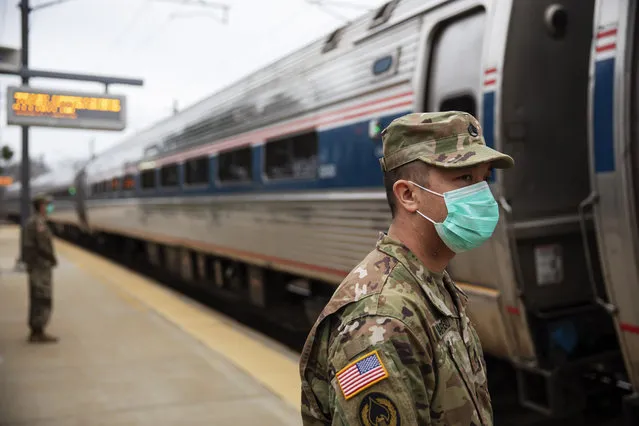 Members of the Rhode Island National Guard look for passengers getting off from a train from New York as it arrives Saturday, March 28, 2020, in Westerly, R.I. States are pulling back the welcome mat for travelers from the New York area, which is the epicenter of the country's coronavirus outbreak, and some say at least one state's measures are unconstitutional. Gov. Gina Raimondo ratcheted up the measures Friday afternoon, announcing she'll also order the state National Guard to go door-to-door in coastal communities starting this weekend to find out whether any of the home's residents have recently arrived from New York and inform them of the quarantine order. (Photo by David Goldman/AP Photo)