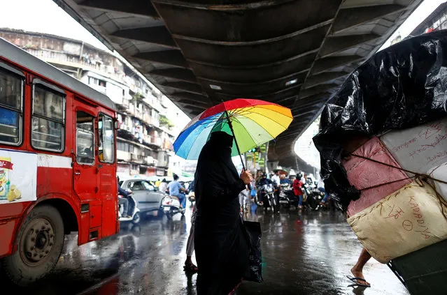 A woman carrying an umbrella crosses a street in Mumbai, India, July 18, 2016. (Photo by Danish Siddiqui/Reuters)