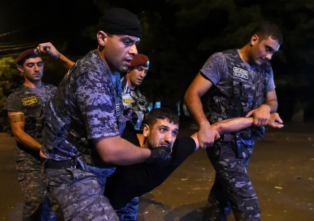 Police officers detain a man during a clash with demonstrators who had gathered in a show of support for gunmen holding several hostages in a police station in Yerevan, Armenia, July 21, 2016. (Photo by Hayk Baghdasaryan/Reuters/Photolure)