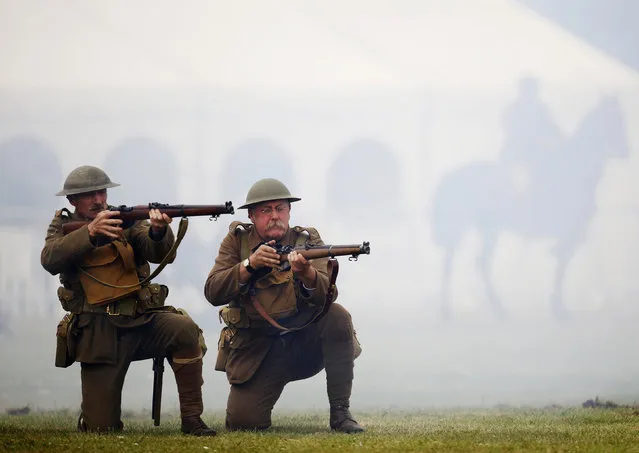 Freight train driver Chris Bingham (R), portraying a private, from the Queen's Own Royal West Kent Living History Group, and carpenter Richard Helad (L), portraying a Lance Corporal, participate in a mock battle illustrating the First World War at the Colchester Military Tournament in Colchester, eastern England July 6, 2014. (Photo by Luke MacGregor/Reuters)