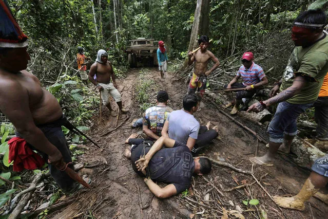 Ka'apor Indian warriors tie up loggers during a jungle expedition to search for and expel them from the Alto Turiacu Indian territory, near the Centro do Guilherme municipality in the northeast of Maranhao state in the Amazon basin, August 7, 2014. (Photo by Lunae Parracho/Reuters)