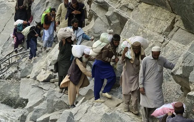 Local residents cross a portion of road destroyed by floodwaters in Kalam Valley in northern Pakistan, Sunday, September 4, 2022. Officials warned Sunday that more flooding was expected as Lake Manchar in southern Pakistan swelled from monsoon rains that began in mid-June and have killed nearly 1,300 people. (Photo by Sherin Zada/AP Photo)