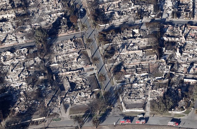 An aerial view of fire trucks parked near homes destroyed in the Palisades Fire as wildfires cause damage and loss through the LA region on January 13, 2025 in Pacific Palisades, California. Multiple wildfires fueled by intense Santa Ana Winds continue to burn across Los Angeles County, with some containment achieved. According to reports, 24 people have died with over 180,000 people under evacuation order or warning. Over 12,000 structures have been destroyed or damaged, while more than 35,000 acres have burned. (Photo by Mario Tama/Getty Images)