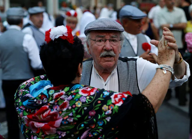 People dance after taking part in the procession of San Cayetano dressed in Madrid's traditional attire “Chulapos” in Madrid, Spain, August 7, 2016. (Photo by Javier Barbancho/Reuters)