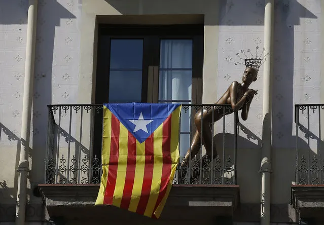 A mannequin stands next to a “estelada” or Catalonia independence flag, on a balcony, in Barcelona, Spain, Monday, October 23, 2017. Catalonia's regional parliament will hold a debate this week on Spain's plan to take direct control of the northeastern region – a session many fear could become a cover for a vote on declaring independence. (Photo by Manu Fernandez/AP Photo)