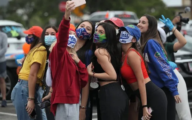 Mia Sanford, graduating from Dr. Michael M. Krop Senior High School, takes a selfie picture with friends before participating in a parade of vehicles celebrating the graduating 2020 High School seniors on May 14, 2020 in Aventura, Florida. The graduating seniors were cheered on as they drove through the city escorted by the Aventura Police Department, students and parents. The unorthodox graduation ceremony was created as a way to safely celebrate during the coronavirus pandemic. (Photo by Joe Raedle/Getty Images)