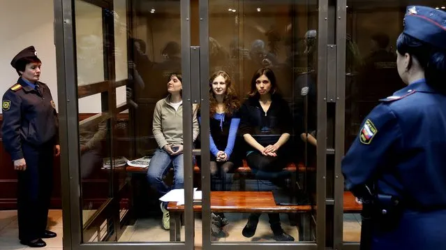 Feminist punk group p*ssy Riot members Maria Alekhina, Yekaterina Samutsevich and Nadezhda Tolokonnikova sit in a glass cage in a courtroom in Moscow, on October 10, 2012. The women are set to make their case before a Russian appeals court that they should not be imprisoned for their irreverent protest against President Vladimir Putin. Their impromptu performance inside Moscow's main cathedral in February came shortly before Putin was elected to a third term. The women were convicted in August of hooliganism motivated by religious hatred and sentenced to two years in prison. (Photo by Sergey Ponomarev/Associated Press)