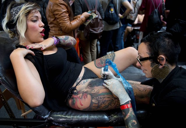 Ffion Green (left) gets a tattoo done by Jo Harrision (right) at the 10th London International Tattoo Convention, east London, on  September 26, 2014. (Photo by Laura Lean/PA Wire)