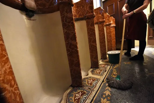 A member of staff cleans the ornate men's toilets in the Philharmonic Dining Rooms in Liverpool, north west England on November 15, 2017. The renowned pub, restaurant and meeting place is Grade II listed building but the gentlemen's toilets within the building are Grade I listed, considered higher in special architectural or historic interest than the building where it sits. (Photo by Paul Ellis/AFP Photo)