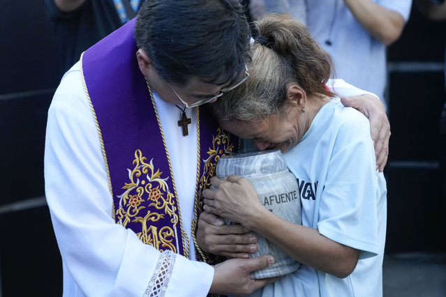 Filipino Catholic priest Flavie Villanueva, left, consoles Melinda Lafuente, as she holds the urn containing the remains of her son Angelo, during an interment ceremony for victims of extrajudicial killings, at the “Dambana ng Paghilom” or Shrine of Healing inside a cemetery in Caloocan City, Philippines, Wednesday March 12, 2025. (Photo by Aaron Favila/AP Photo)